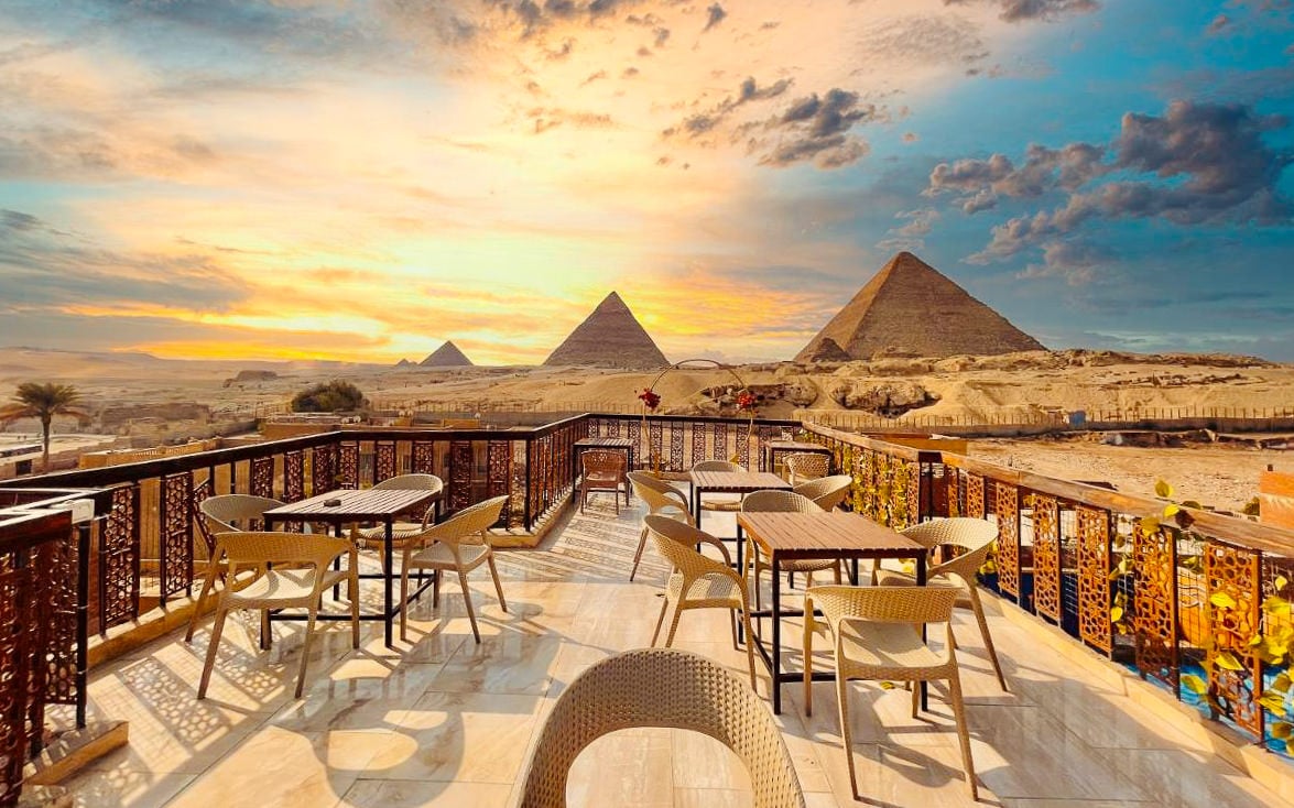 Scenic rooftop terrace with view of the Great Pyramids of Giza at sunset – Cairo cultural tour with Aquila Adventures, Egypt